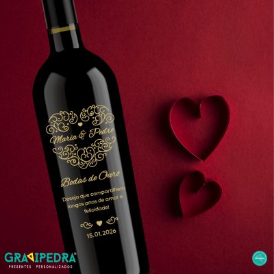 Garrafa de vinho personalizada com texto dourado para bodas de ouro, sobre fundo vermelho com moldes de coração.