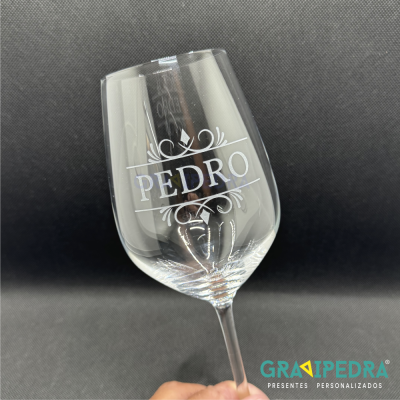 Taça de vidro transparente com nome PEDRO gravado e fundo preto.