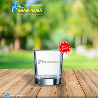 Copo de vidro com gravação personalizada do nome Francisco sobre bancada de madeira
