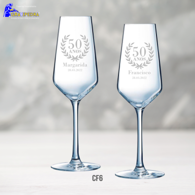 Duas taças de champanhe em vidro gravadas com nomes e datas para celebração de 50 anos