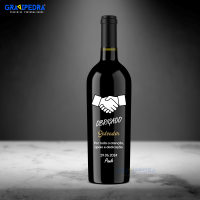 Garrafa de vinho preta com rótulo personalizado com texto de agradecimento e desenho de mãos a apertar-se