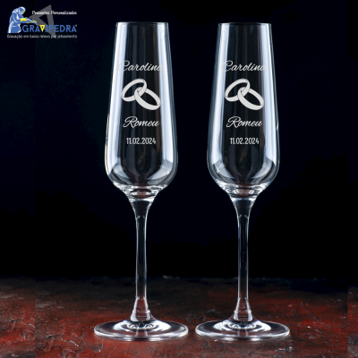 Duas taças de champanhe gravadas personalizadas com nomes, alianças e data.