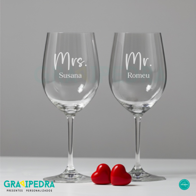 Dois copos de vinho transparentes com texto branco e dois corações vermelhos