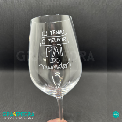 Copo de vidro com mensagem para o melhor pai do mundo, fundo preto.