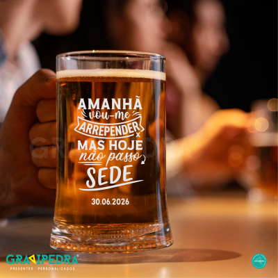 Caneca de vidro com cerveja e texto branco em ambiente de bar com pessoas ao fundo desfocado.