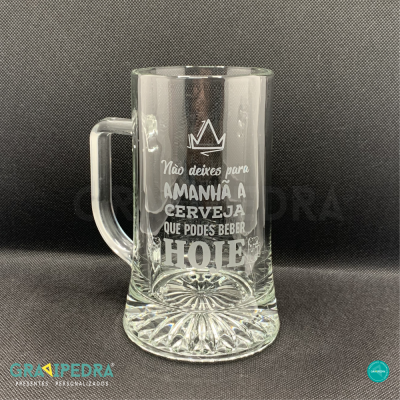 Caneca de vidro transparente com mensagem gravada em branco sobre fundo preto