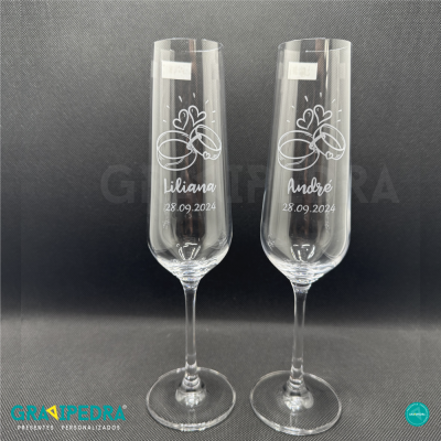 Dois copos de champanhe personalizados com nomes e data de casamento.