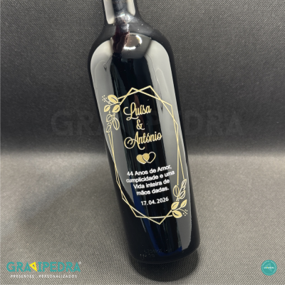 Garrafa de vinho preta com texto dourado comemorativo