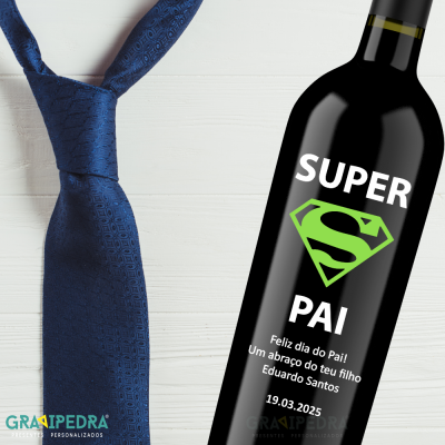 Garrafa de vinho preta com rótulo 'SUPER PAI' e gravata azul pó sobre superfície branca
