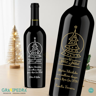 Garrafa de vinho preta com rótulo natalício personalizado e árvore de Natal dourada ao fundo