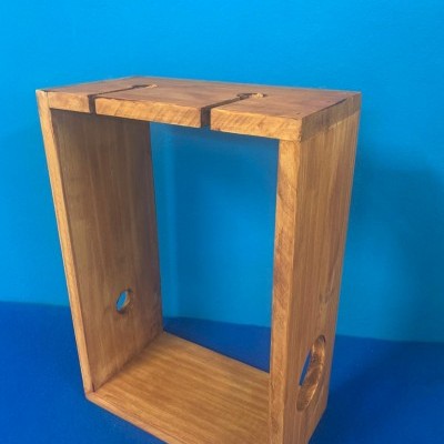 Estrutura retangular de madeira com buracos circulares em fundo azul