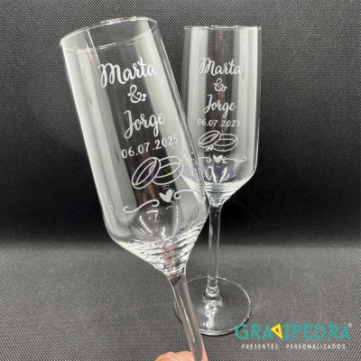 Duas taças de champanhe personalizadas com nomes, data e ilustração de alianças