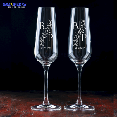 Dois copos de champanhe personalizados com letras e data em gravura branca.