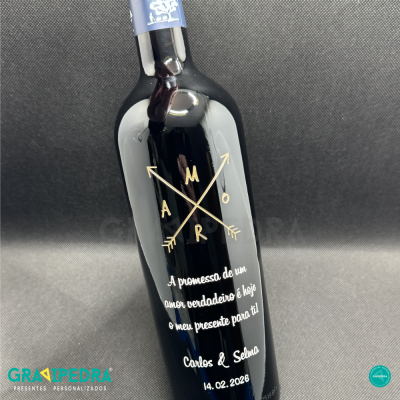 Garrafa preta com rótulo personalizado com texto em branco e dourado e fundo cinza