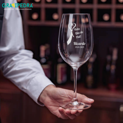 Copo de vidro para vinho com gravação personalizada sobre fundo de adega