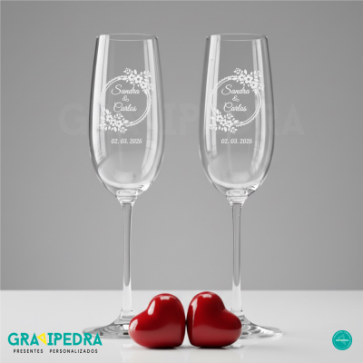 Duas taças de champanhe personalizadas com corações vermelhos em base branca.