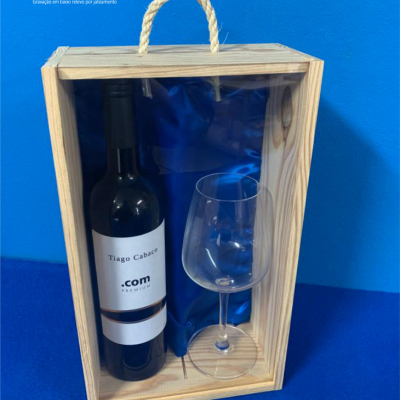 Caixa de presente de madeira com garrafa de vinho e taça, fundo azul
