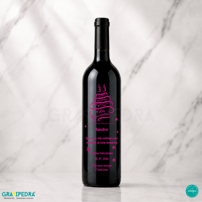 Garrafa de vinho preta com design rosa de aniversário e mensagem personalizada sobre fundo branco marmoreado