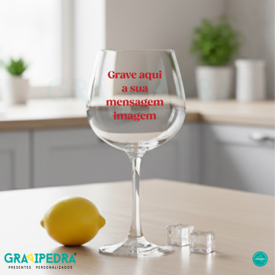 Taça de vinho com texto personalizado, limão e cubos de gelo numa cozinha moderna.