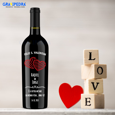 Garrafa de vinho decorada com mensagem de São Valentim, ao lado de blocos de madeira formando 'LOVE' e coração vermelho