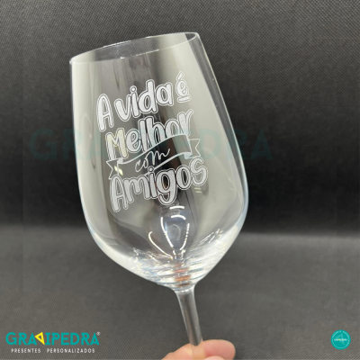 Copo de vidro transparente com texto gravado 'A vida é melhor com amigos'