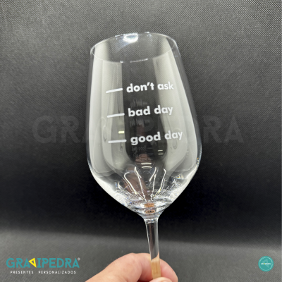 Copo de vinho transparente com texto branco e níveis de bebida num fundo preto