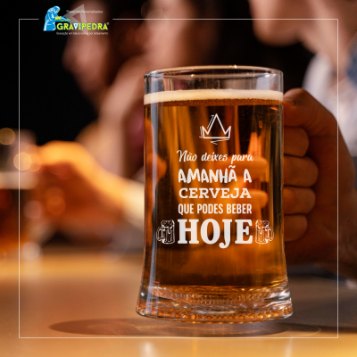 Copo de cerveja com texto motivacional em português e uma mão segurando-o