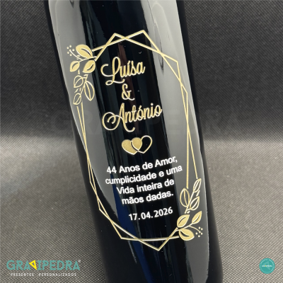 Garrafa preta personalizada com texto dourado e branco a celebrar 44 anos juntos.