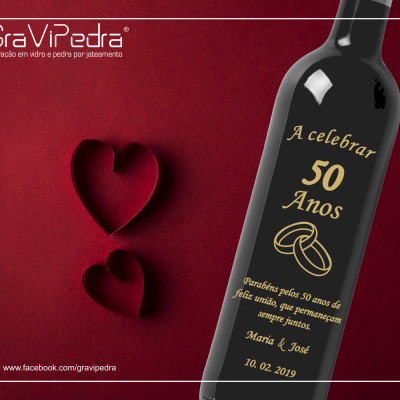 Garrafa de vinho com rótulo comemorativo de 50 anos e fundo vermelho com corações de papel