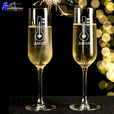 Duas taças de champanhe com desenho de termómetro, coração, AMOR e data 14.02.2022, luzes douradas ao fundo