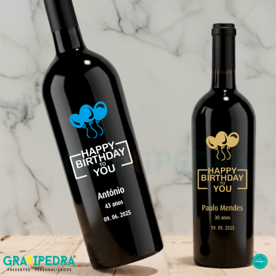 Duas garrafas de vinho tinto com rótulos personalizados para aniversário sobre fundo branco marmoreado