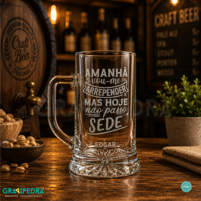 Caneca de vidro transparente com frase gravada em branco e nome personalizável sobre mesa de madeira em ambiente rústico