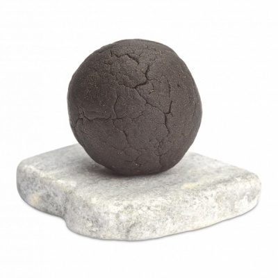 Bola preta texturada sobre base de pedra cinzenta