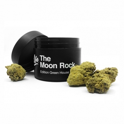 Frasco preto com texto branco 'The Moon Rock Edition Green House' e pedaços verdes ao redor