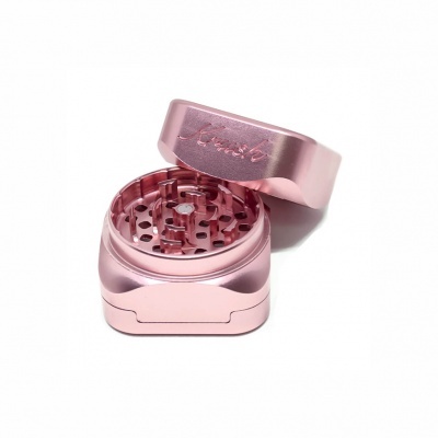 Triturador de ervas de metal cor de rosa com tampa e pequenos furos