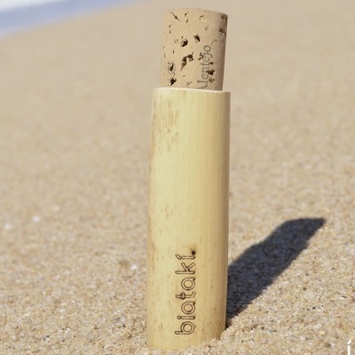 Frasco em bambu com tampo de cortiça na areia da praia