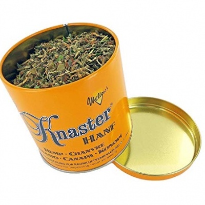 Lata amarela aberta com mistura de ervas secas e texto Knaster HAWK