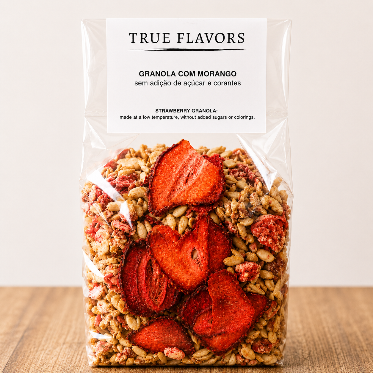 True Colors Granola com Morango Pacote transparente de granola com morango, mostrando fatias secas de morango e rótulo branco