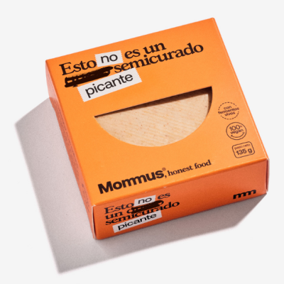 Embalagem laranja de produto com texto Esto no es un semicurado picante e janela transparente mostrando o alimento.