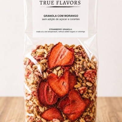 Pacote transparente de granola com morango com etiqueta branca e texto preto