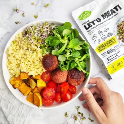 Prato com cuscuz, legumes e almôndegas veganas, embalagem do produto LETS MEAT! ao lado.