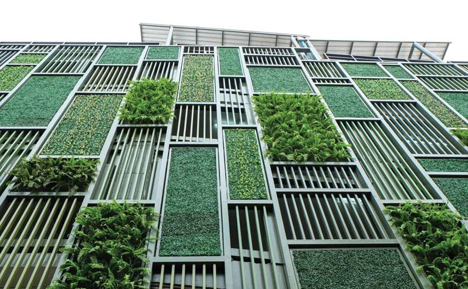 Fachada decorativa com painéis verdes em molduras metálicas dispostas verticalmente