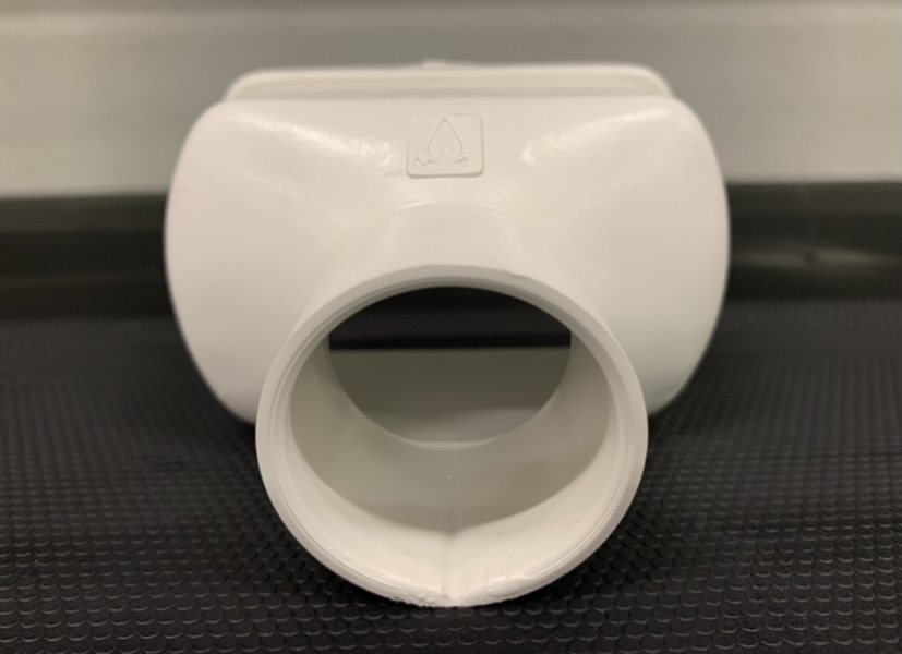 Topo con descarga para Perfil Producción Encaixe de tubo branco em plástico com símbolo gravado sobre superfície preta