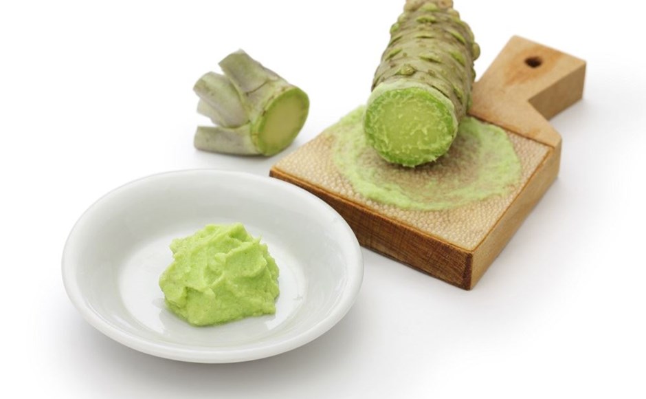 Raiz de wasabi cortada com pó e pasta de wasabi em tigela branca