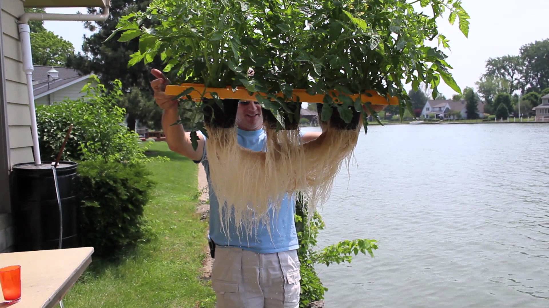 Pessoa segurando prancha com fios longos perto de lago em ambiente exterior