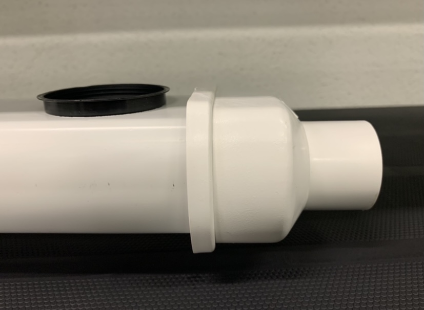 Topo con descarga para Perfil Producción Tubo de plástico branco com tampa preta sobre superfície preta.