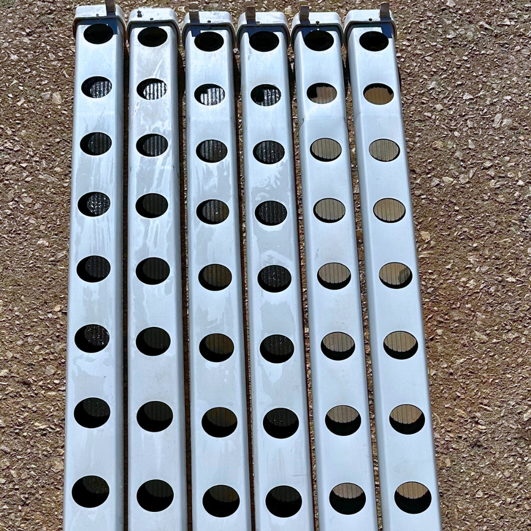 1 metro Perfil Perforado de 80 mm con Tapón - Segunda mano Sete barras metálicas prateadas com orifícios circulares alinhadas sobre solo marron