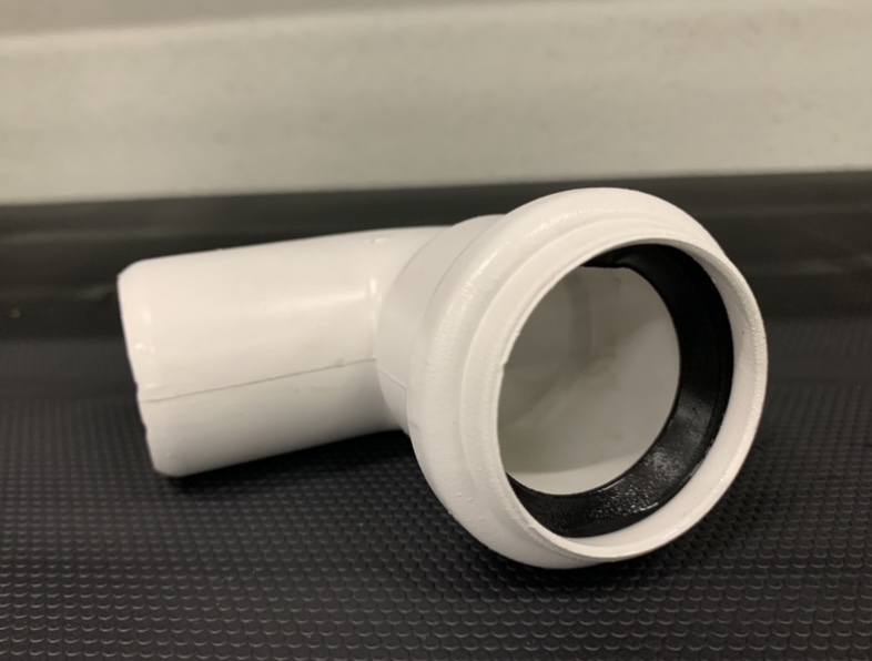 Rodilla PVC DIN Blanco 90º Ø40 mm Conector de cano branco em L com junta preta numa superfície preta