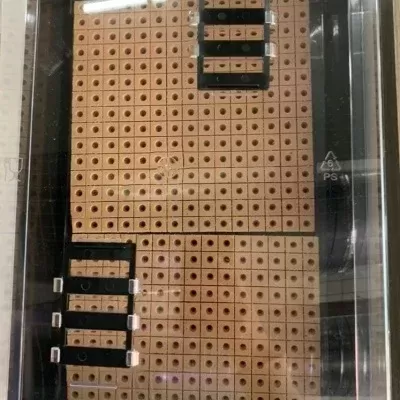 Conjunto de quadros perfurados castanhos com buracos e etiquetas pretas embalados em plástico transparente