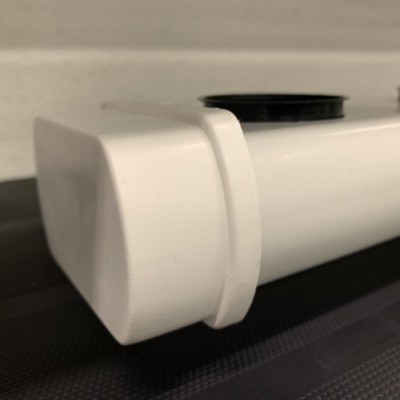 Tubo branco com tampas pretas em superfície preta